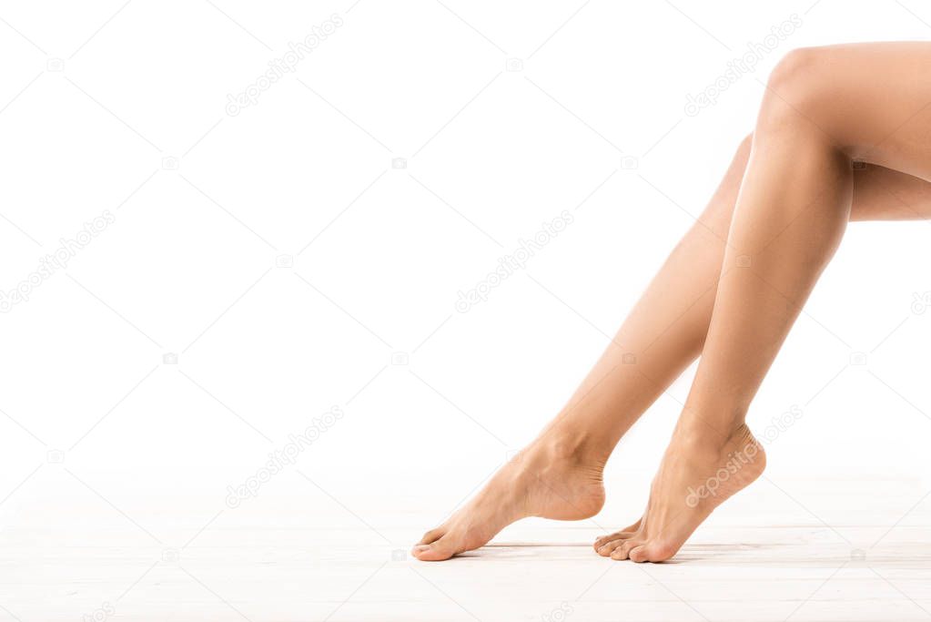 partial view of beautiful slim smooth female legs on white 