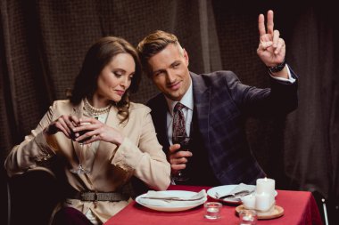 cam veya kırmızı şarap mimik ve garson için arama sırasında romantik tarih restoranda yakışıklı adam tutan kadın