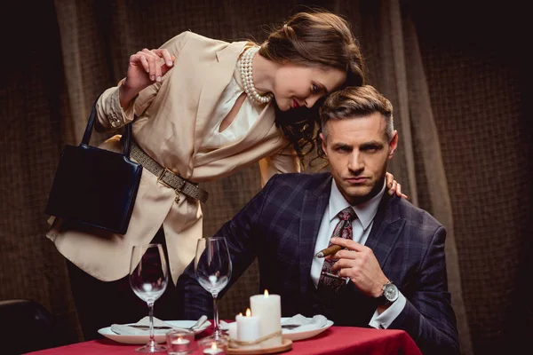 Woman Embracing Serious Handsome Man Cigar Romantic Date Restaurant — Stock Photo, Image