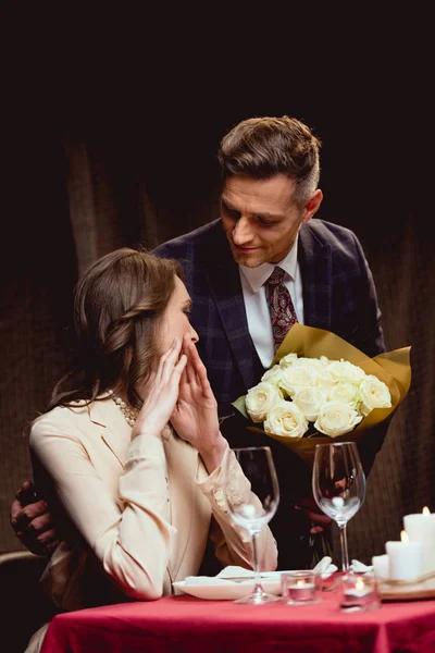 Man Presenting Flowers Surprised Woman Romantic Date Restaurant — Stock Photo, Image