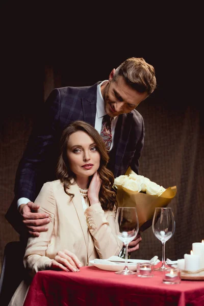 Homem Apresentando Flores Para Mulher Bonita Durante Data Romântica Restaurante — Fotografia de Stock