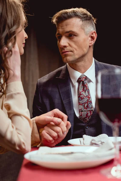 レストランでロマンチックなデートをしながら手を繋いでいるカップルの選択と集中 — ストック写真