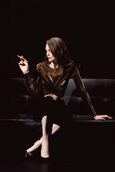 Femme Glamour Assis Sur Canapé Fumer Cigarette Isolé Sur Noir — Photo