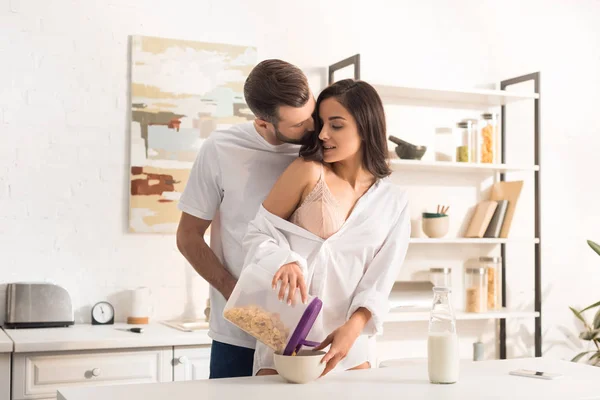 年轻夫妇拥抱 而在家里吃早餐 — 图库照片