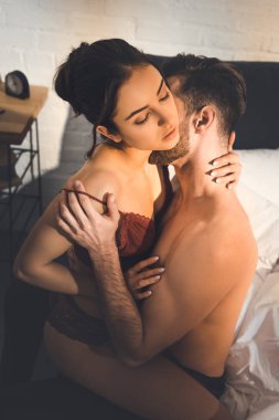 tutkuyla evde yatakta kucaklayan güzel seksi çift