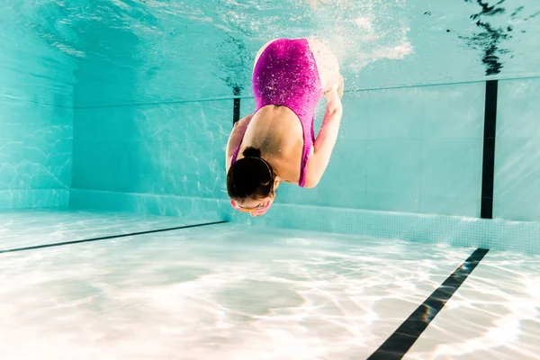 ピンクの水着姿の女性がスイミングプールで水中で — ストック写真