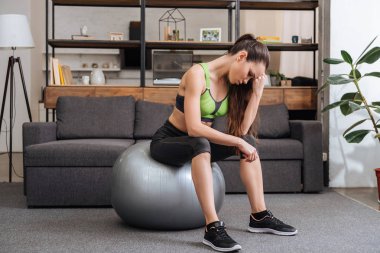 yorgun sporcumuz fitness topu evde oturma odasında oturup...