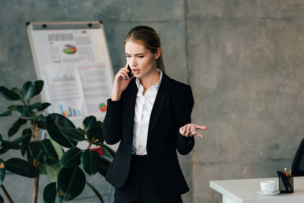 serious businesswoman talking on smartphone in office 