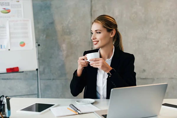 Hübsche Lächelnde Geschäftsfrau Sitzt Arbeitsplatz Und Trinkt Kaffee — Stockfoto