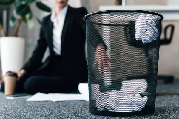 Selective Focus Crumpled Paper Basket While Businesswoman Sitting Floor — Stock Photo, Image