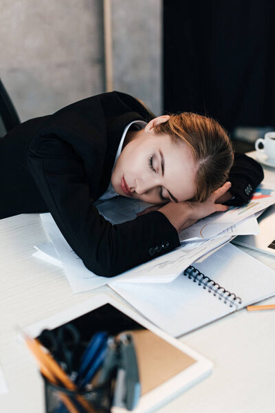 selective focus of exhausted businesswoman sleeping at work-table