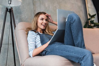 gülümseyen ve laptop monitör seyir sürpriz genç kız
