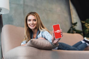 güzel kadının elinde Youtube Web sitesi ile akıllı telefon seçici odak
