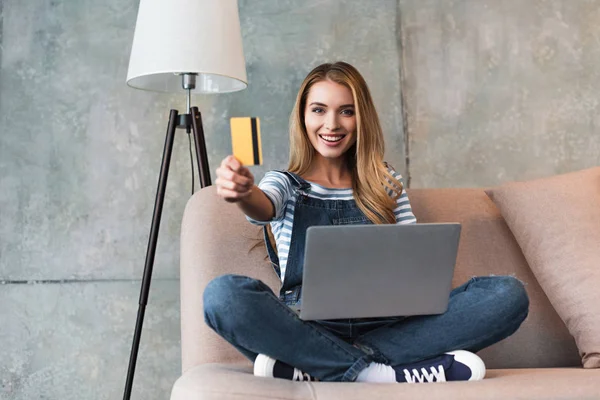 Schöne Frau Zeigt Kreditkarte Und Sitzt Auf Sofa Mit Laptop — Stockfoto