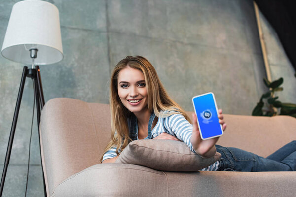 селективный фокус смартфона с приложением shazam в руке молодой девушки
