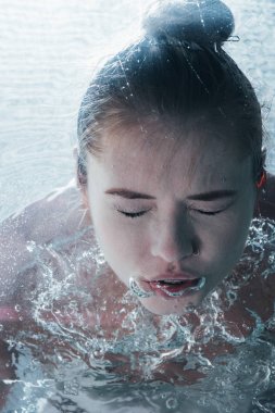 Genç kadının su altında kapalı gözlerle poz kapat