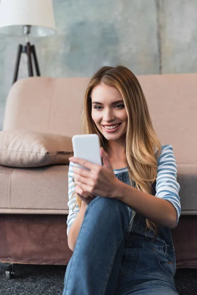 Jovem Mulher Usando Smartphone Sentado Perto Sofá Rosa — Fotografia de Stock