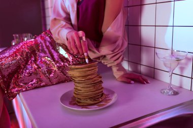 cropped view of woman putting out cigarette in pancakes in kitchen clipart