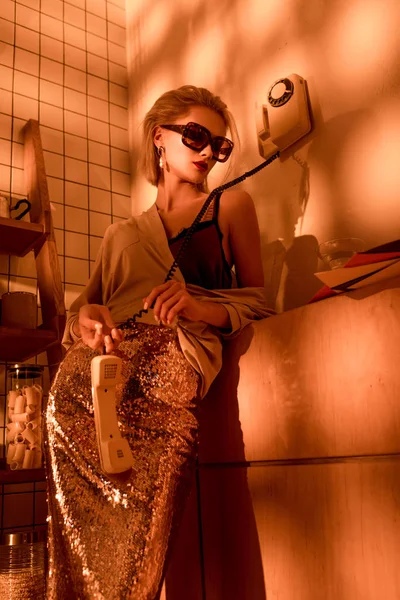 Eleganta Kvinnan Solglasögon Håller Retro Telefon Kök Med Orange Ljus — Stockfoto