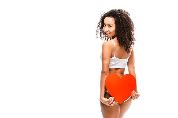 african american girl in underwear holding heart shaped card and looking at camera isolated on white