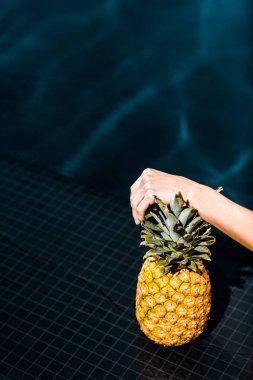 yüzme havuzu yanında taze ananas ile poz kadının kısmi görünümü