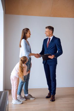 yakışıklı broker kızıyla duran güzel kadın ile el sıkışan