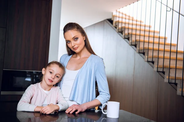 Lycklig Mamma Står Med Söt Dotter Nära Kopp Kaffe — Stockfoto