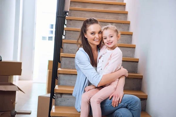 Fröhliche Frau Sitzt Mit Tochter Neuen Zuhause Auf Der Treppe — Stockfoto