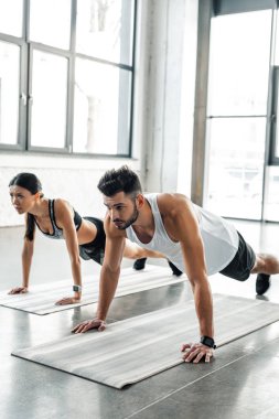 spor giyim itme yapıyor atletik genç çift ups spor salonunda yoga paspaslar 