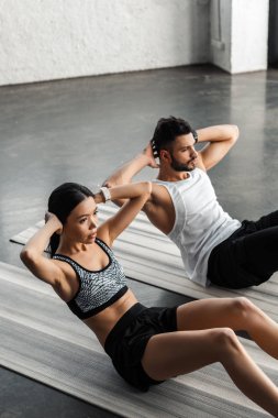 genç çiftin spor salonunda yoga paspaslar üzerinde abs egzersiz yaparak yüksek açılı görünüş