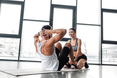 gülümseyen sportif kız genç sporcu spor salonunda yoga mat ABS egzersiz yaparak yardım