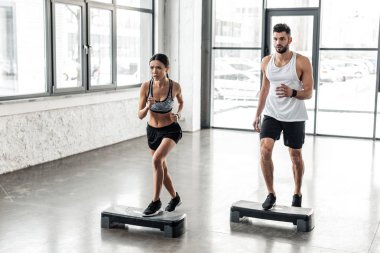 adım platformlar içinde jimnastik salonu kas genç adam ve birlikte üzerinde egzersiz güzel sportif kız 