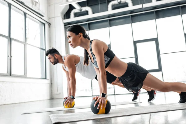 Zijaanzicht Van Jonge Sportieve Paar Uitoefenend Met Geneeskunde Ballen Yoga — Stockfoto
