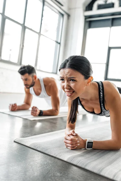 Konzentrierte Junge Frau Und Mann Sportbekleidung Machen Brettgymnastik Auf Yogamatten — Stockfoto