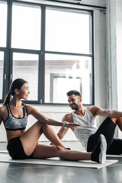 微笑运动的年轻夫妇训练瑜伽垫在健身房 — 图库照片