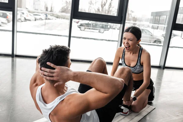 Emocionální Sportovní Mladá Žena Křičela Pomáhá Atletický Muž Dělá Abs — Stock fotografie