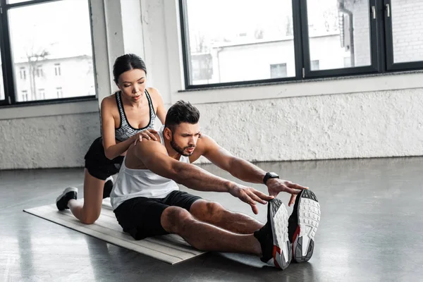 Hermosa Mujer Entrenador Ayudar Joven Deportista Estiramiento Yoga Mat Gimnasio — Foto de Stock