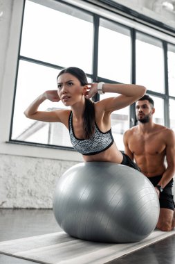 gömleksiz erkek Trainer fitness Ball spor salonunda egzersiz sportif kıza yardım düşük açılı görünüş