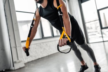 spor salonunda direnç bands ile egzersiz kas genç adam resmini kırpılmış
