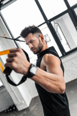 spor salonunda askı kayışları ile egzersiz ciddi yakışıklı genç
