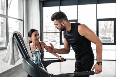 spor salonunda treadmill çalıştıran atletik erkek genç sporcumuz bakarak yorgun