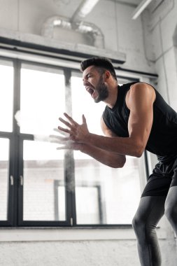 düşük açılı görünümü çığlık ve talk pudrası uygulayarak agresif sporcu spor salonunda eller