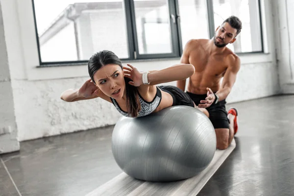 Homem Sem Camisa Muscular Olhando Para Menina Desportiva Exercitando Bola — Fotografia de Stock