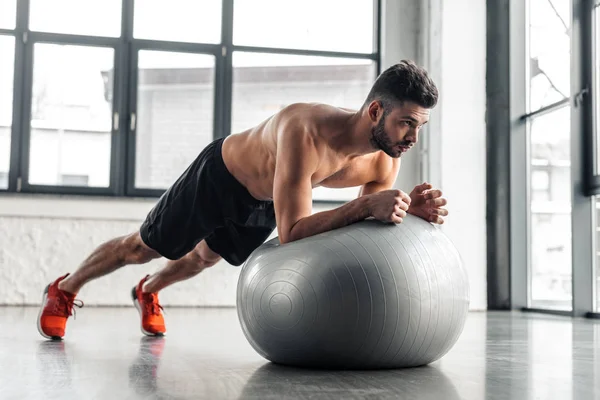 Jovem Sem Camisa Muscular Fazendo Exercício Prancha Bola Fitness Ginásio — Fotografia de Stock