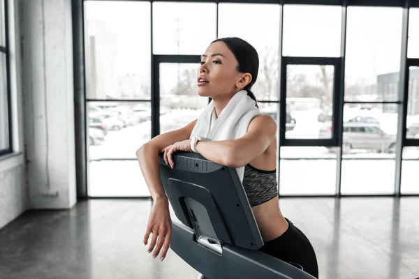 Exhausted Young Sportswoman Towel Neck Leaning Treadmill Looking Away Gym — Stock Photo, Image