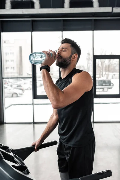 Athletischer Junger Mann Trinkt Wasser Während Fitnessstudio Auf Dem Laufband — Stockfoto