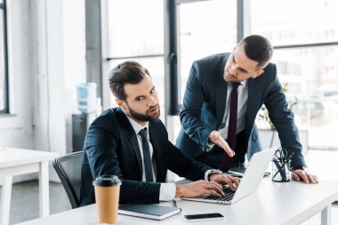 seçici odak memnun işadamı laptop formal giyim duygusal adam yakınındaki yazarak