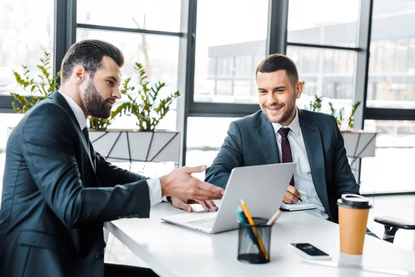 Bonito Empresário Mostrando Algo Laptop Para Sorrir Colega Trabalho Escritório — Fotografia de Stock