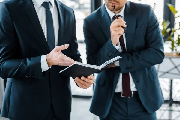 Vista Ritagliata Uomo Affari Possesso Notebook Vicino Collega Ufficio Moderno — Foto Stock