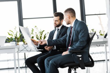 modern ofis gazetede, parmakla işaret eden işadamı 